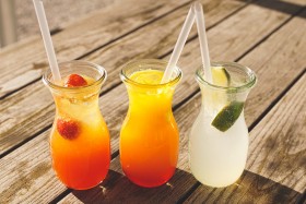 three fruit slushies on a wood table